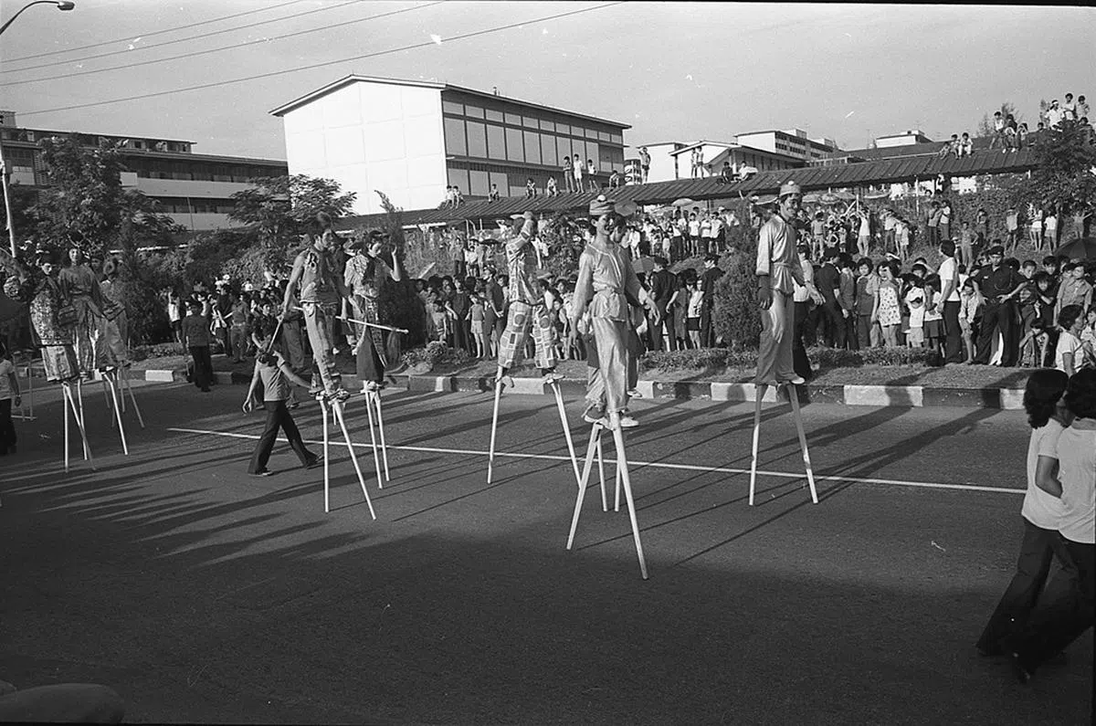 高跷演者走出立道中学，吸引不少路人驻足围观。（南洋商报）