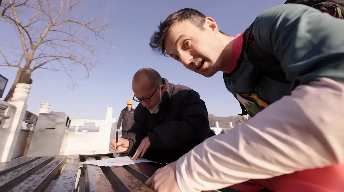 麦克唐纳在万里长城找到工作人员签名作为证明。（视频截图）