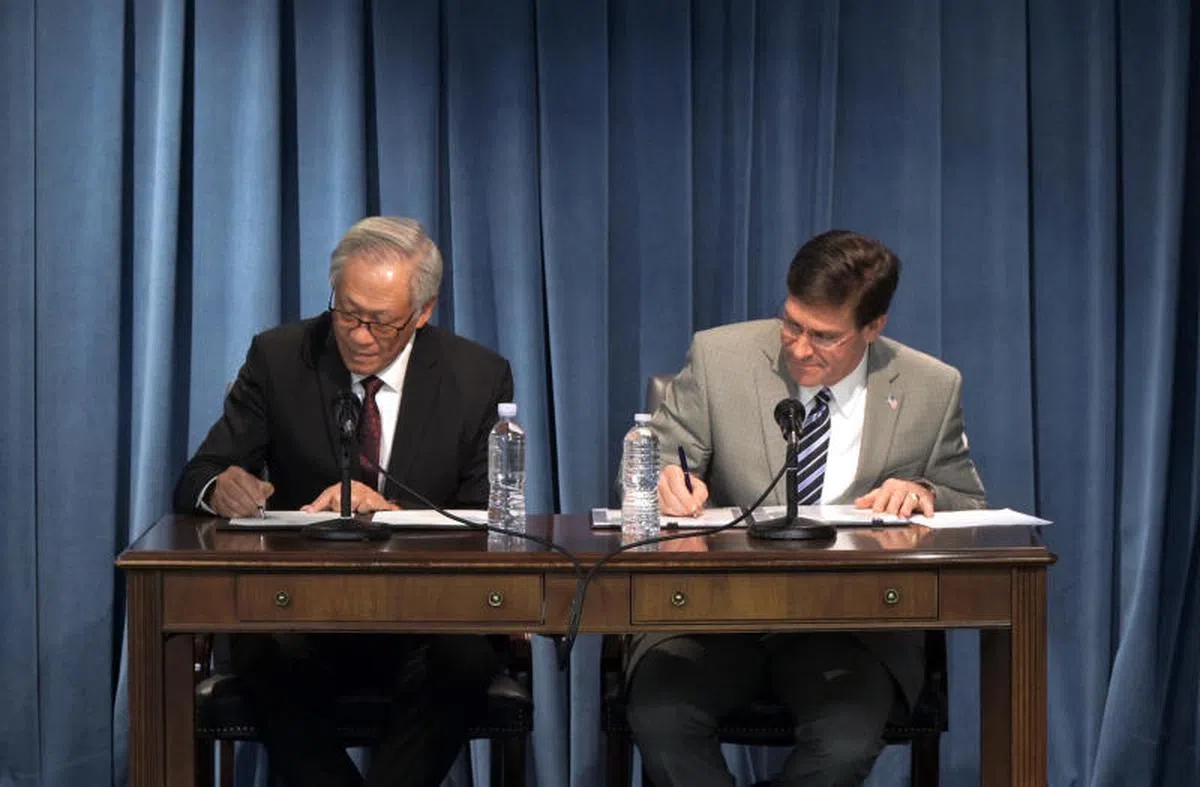  出访美国的新加坡国防部长黄永宏（左）与美国防长埃斯珀就新加坡空军部队在关岛设立战斗机训练分遣队签署谅解备忘录。（黄永宏面簿） 