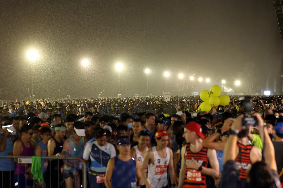 数以万计的选手在雨中参与12月4日的渣打银行马拉松赛。（海峡时报）