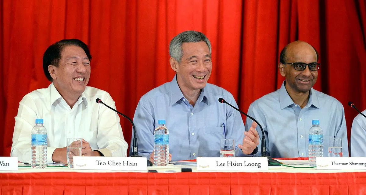 2015年9月28日，李显龙总理（中）在总统府召开记者会宣布新内阁阵容，其中张志贤副总理（左）兼任国家安全统筹部长，副总理尚达曼则兼任经济及社会政策统筹部长。（新报）