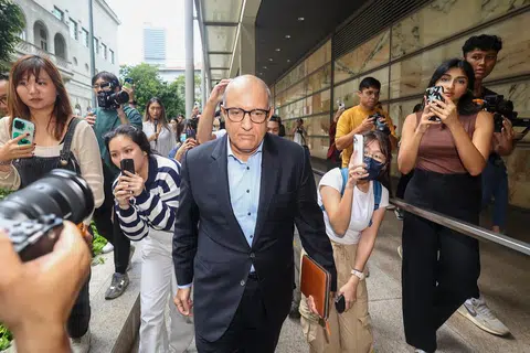 10月3日下午，易华仁在记者的包围下离开高等法院大厦。（联合早报）