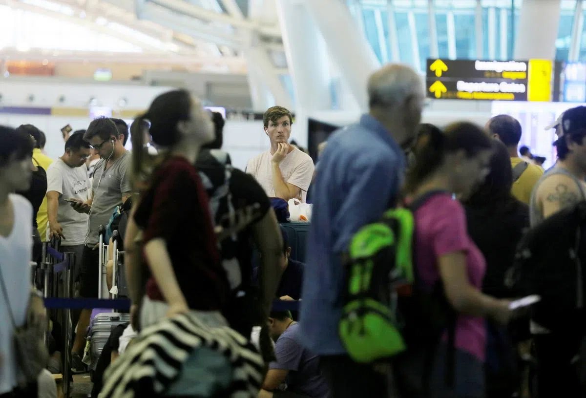  印尼巴厘岛的峇厘岛努拉雷国际机场，大批国际旅客在柜台排队等候。（路透社） 