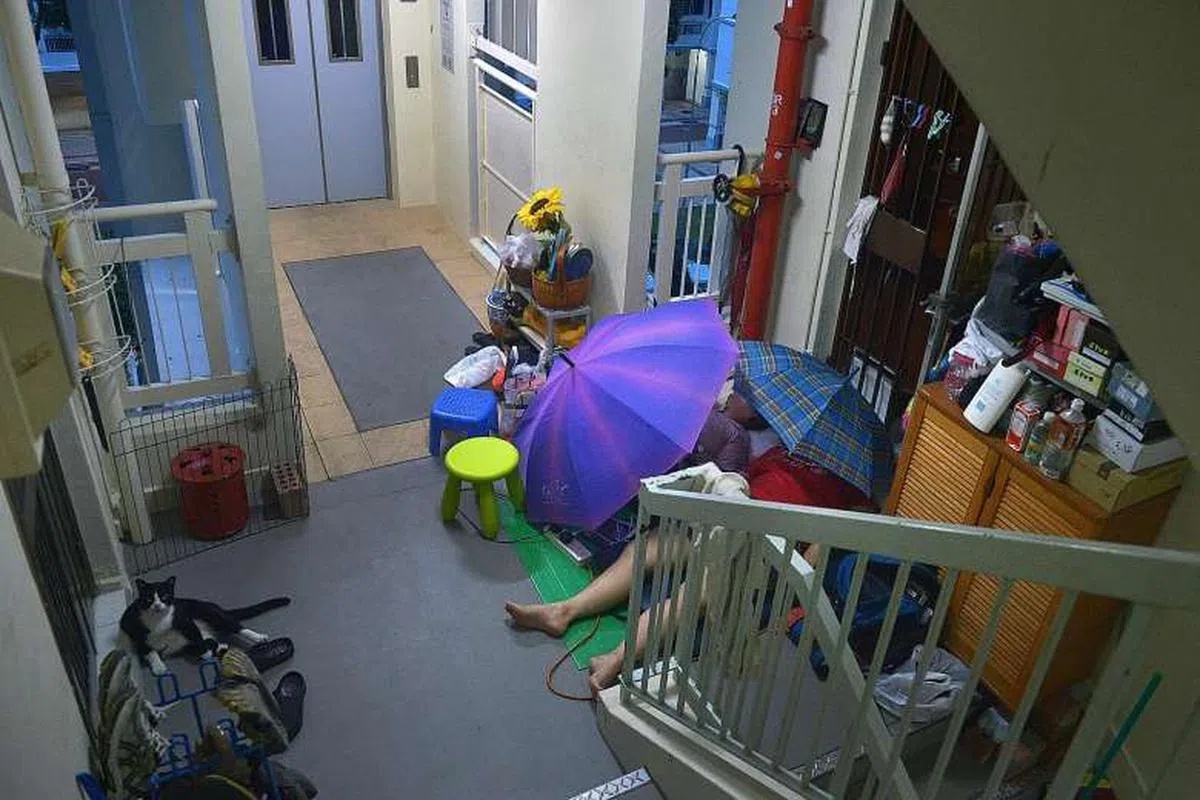  母女俩就这样睡在自家组屋外。（海峡时报） 