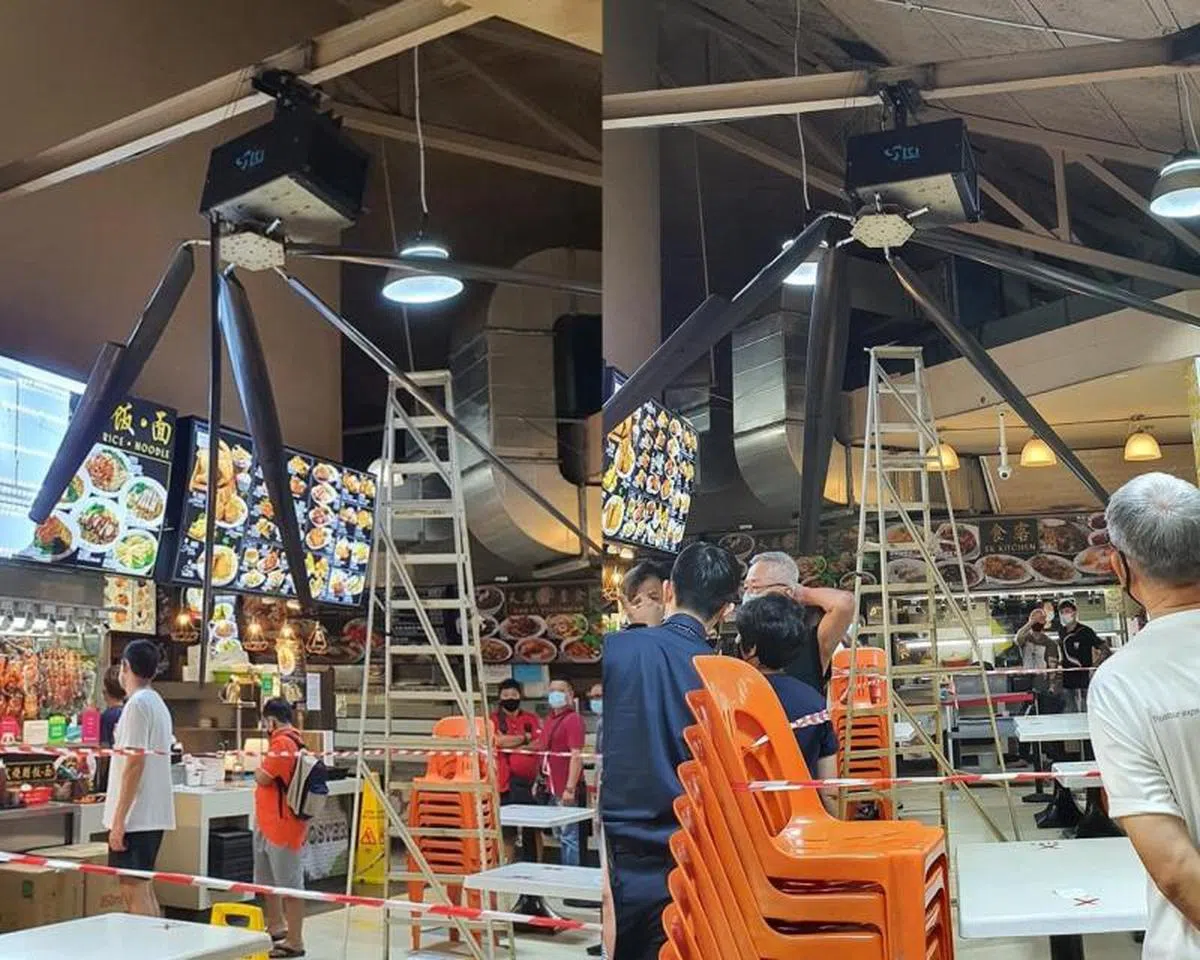  损坏的巨型吊扇仍吊挂在半空中，长长的扇叶片已扭曲变形，后面则是引起事故的活动梯子。（Ang Bee Tin面簿） 