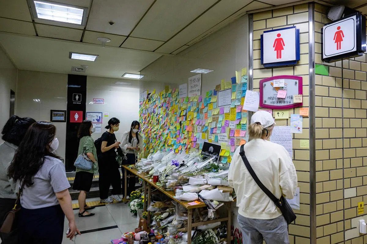 一名韩国女子被追踪多年的男同事杀害，震惊全国，当地民众到案发现场鲜花。（法新社）
