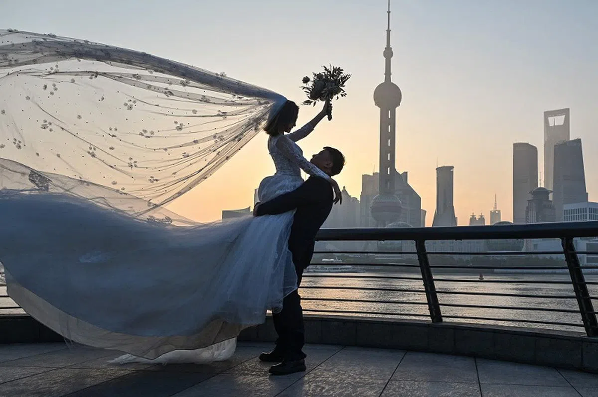 中国国家统计局发出的问卷围绕生育计划、结婚相关政策等议题。图为一对中国情侣在上海拍摄婚纱照。（法新社）