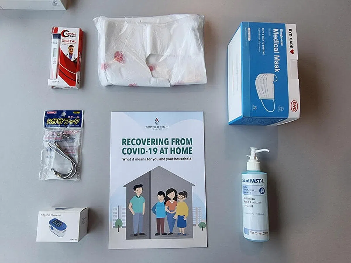 卫生部为居家康复计划的冠病患者提供“关怀礼包”，有一本指南、医用口罩、搓手液、血氧仪、温度计、S型挂钩和塑料袋。（卫生部）