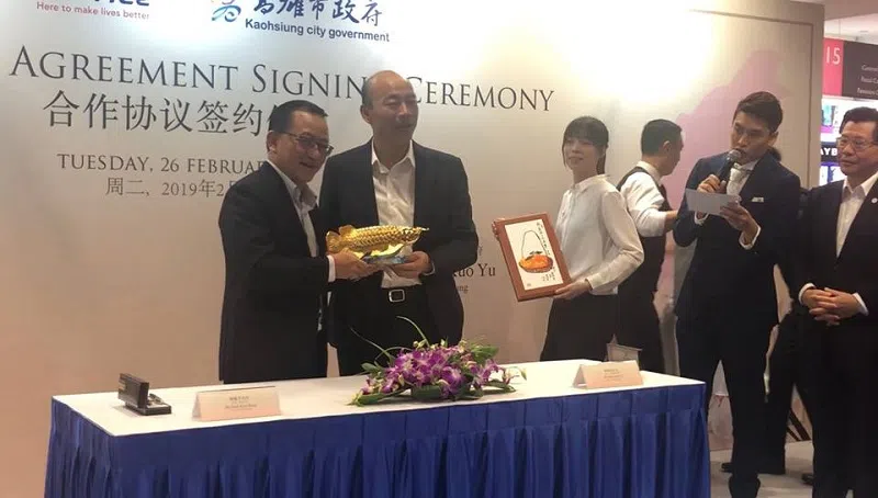  韩国瑜（左二）从谢健平（左一）接过黄金鲤鱼。（侯佩瑜摄 