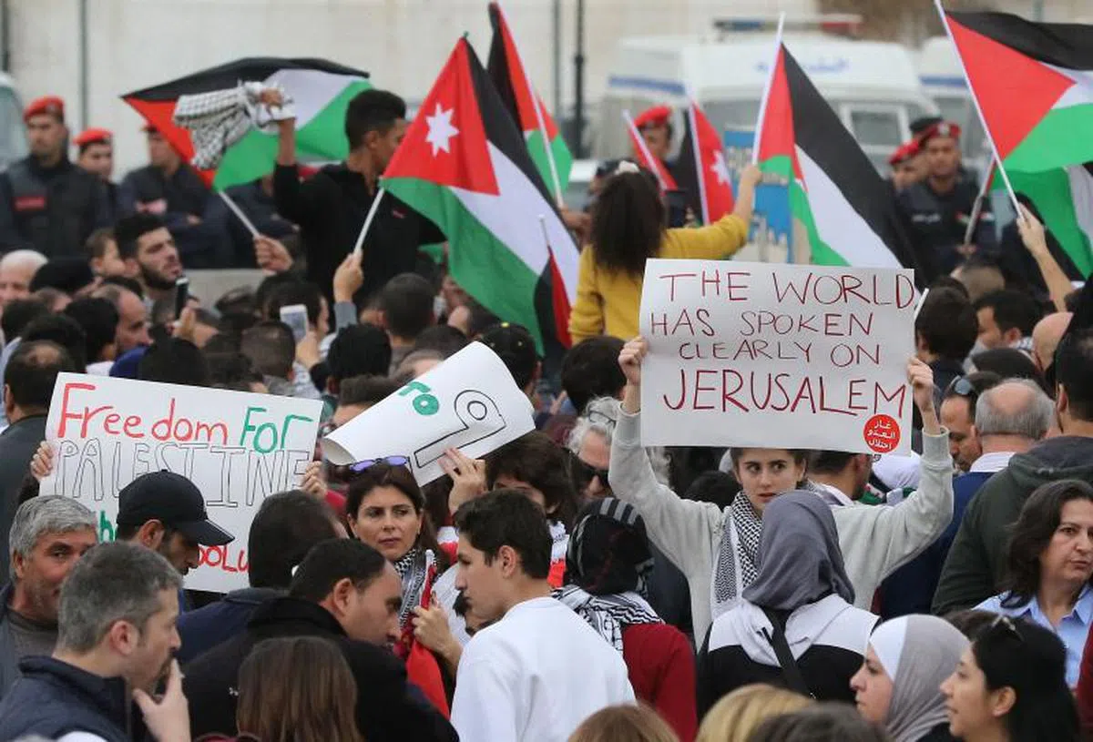  愤怒的示威者去年12月22日在约旦首都安曼的美国大使馆外面举起标语和旗帜抗议美国总统特朗普宣布承认耶路撒冷作为以色列首都。（法新社） 