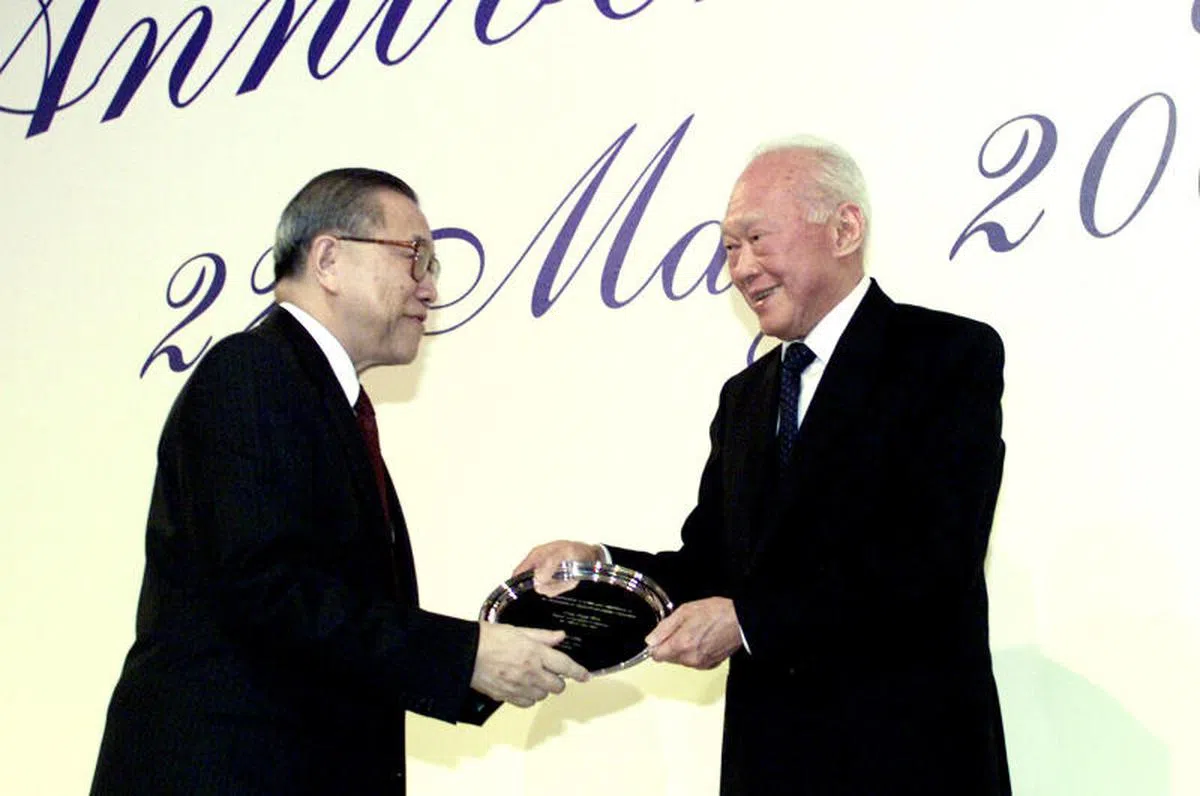  杨邦孝（左）加入司法界之前，也曾出任新加坡政府投资公司执行董事，图为2001年政府投资公司（ GIC ）20周年晚宴上，已故建国总理、也是政府投资公司主席的李光耀资政，颁发纪念牌给政府投资公司董事部成员之一的杨邦孝。（联合早报档案照） 