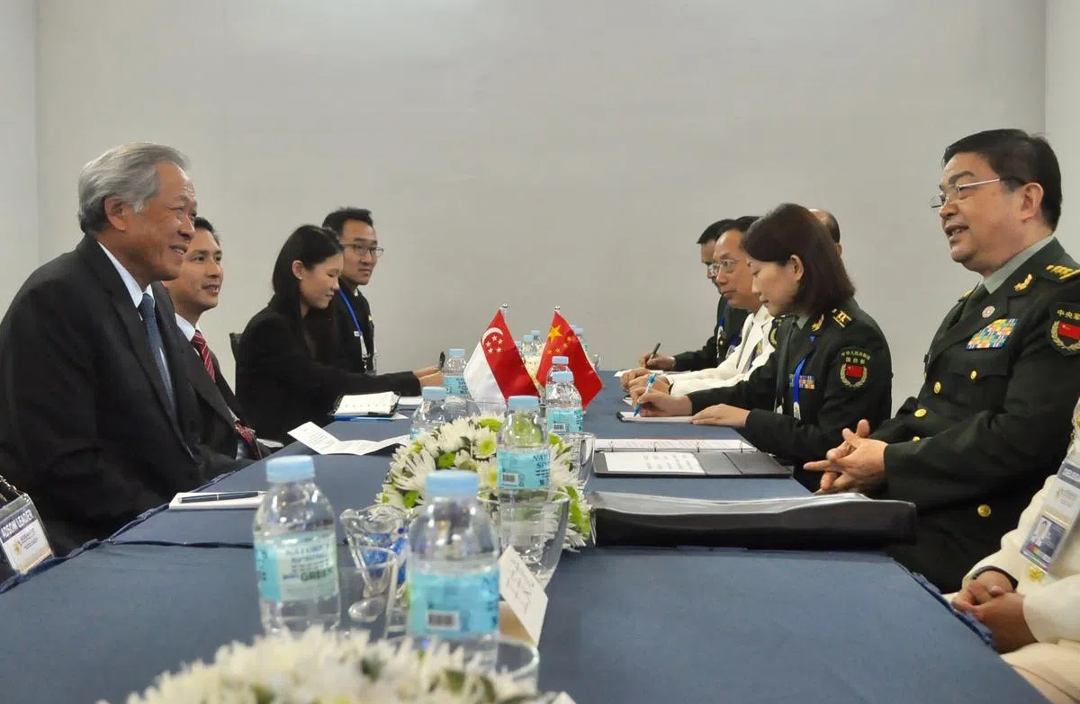  在菲律宾出席亚细安国防部长会议和亚细安加八国防长会议的黄永宏（左一），去年10月23日在场边会见中国国防部长常万全（右一）。（新加坡国防部提供） 
