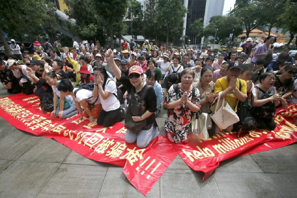 中国籍受害者跪地哭诉，唱国歌，双手合十求中国驻马来西亚大使馆帮助。（光华网）