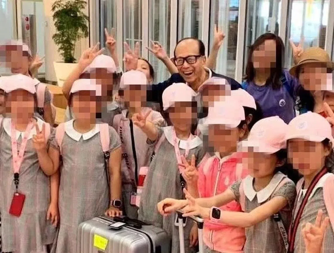 李嘉诚开心地和孩子们合照。（微博）