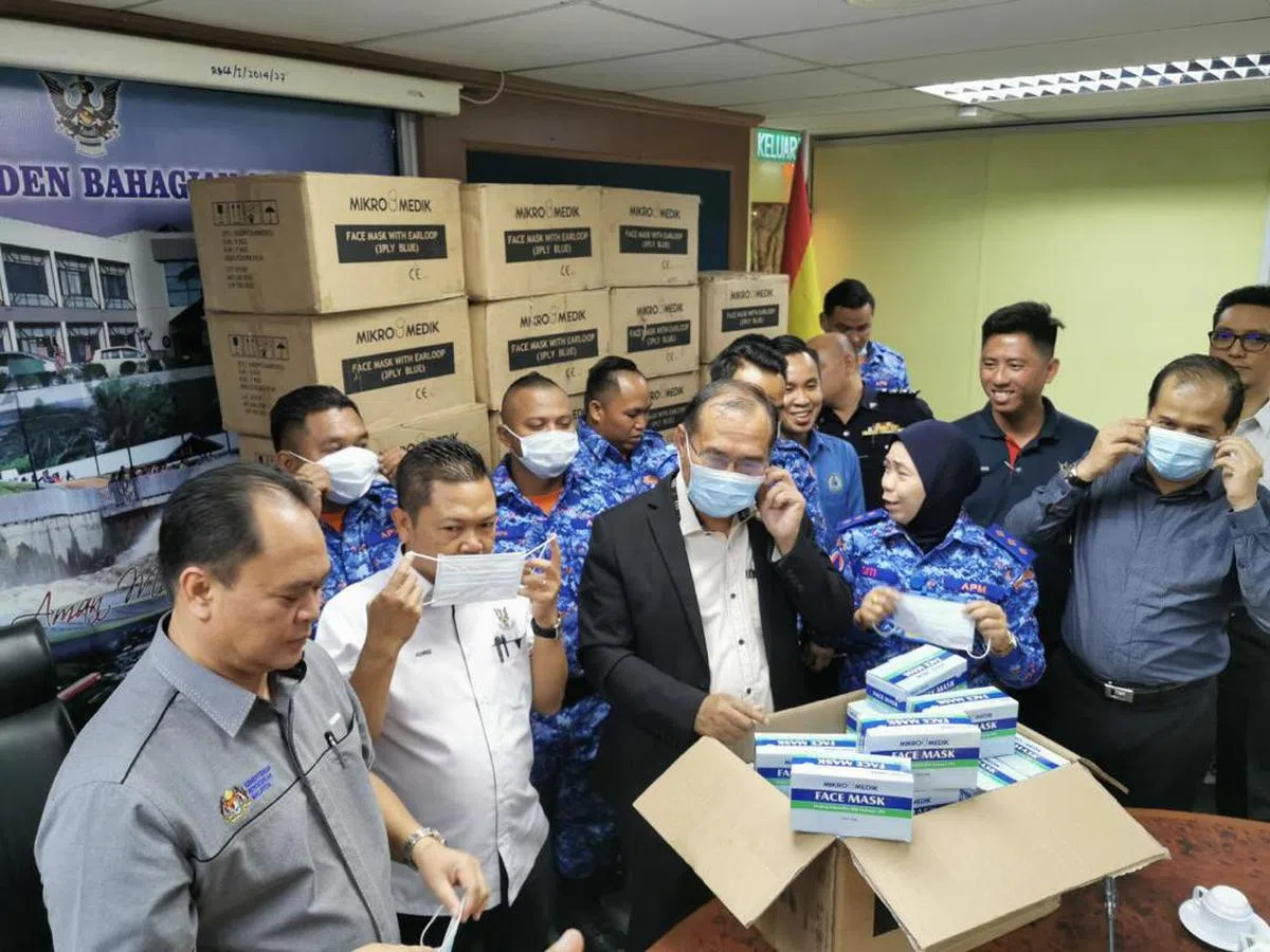  当局官员从箱子里拿出医疗口罩戴上。（马新社推特） 