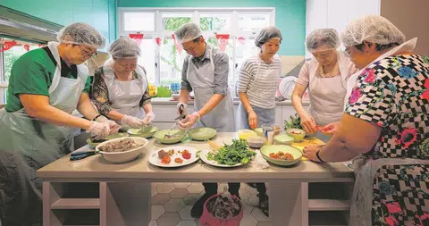 厨尊最新一批学员在位于太平洋活动中心（Pacific Activity Centre）的厨房里忙得不亦乐乎。（海峡时报）