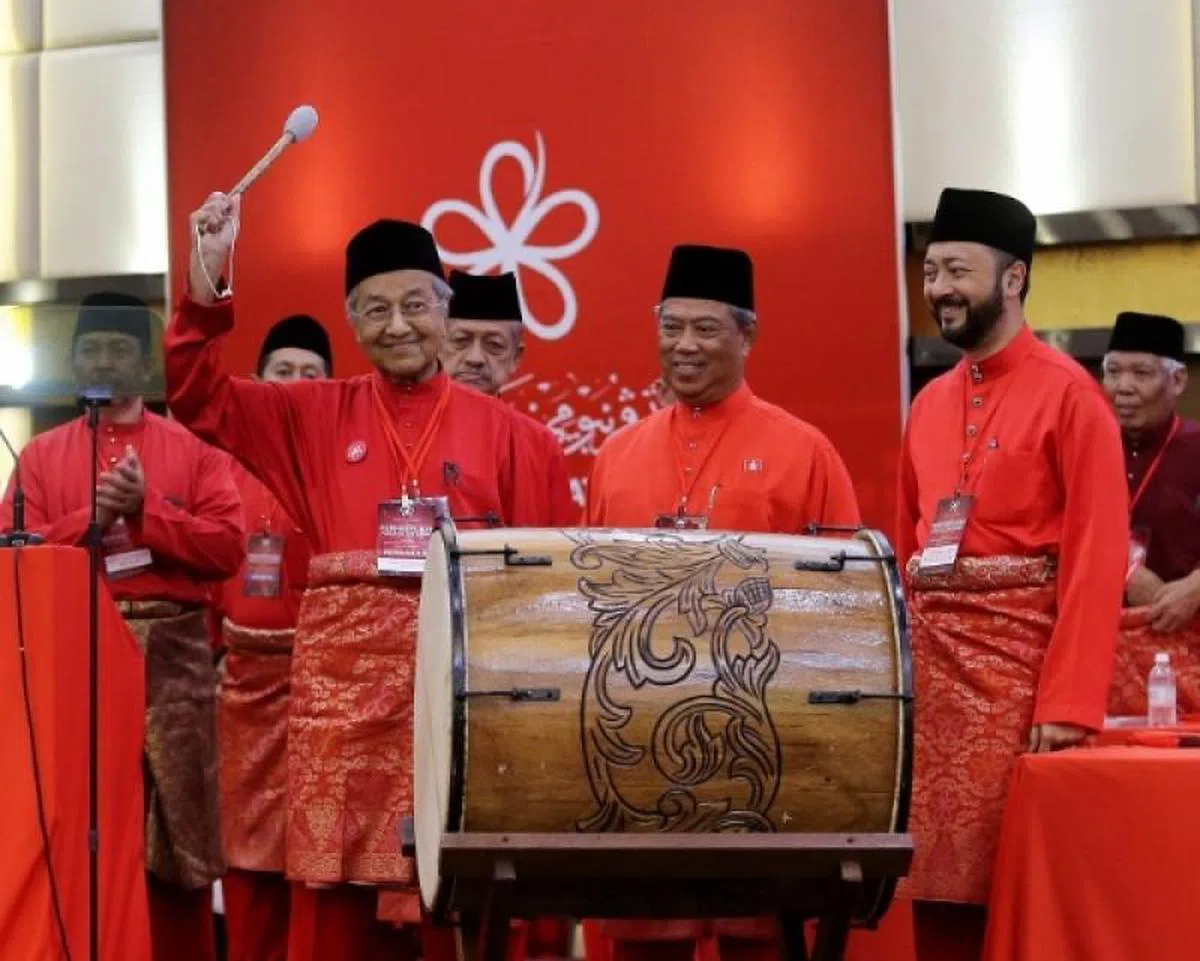  慕尤丁（中）与马哈迪（左）和马哈迪的儿子慕克力，2017年在土团党成立仪式上愉悦击鼓的合照。（星洲日报） 