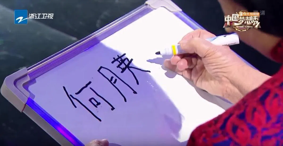  何月英在节目现场一笔一划认真地写下自己的华文名字。（Youtube截图） 