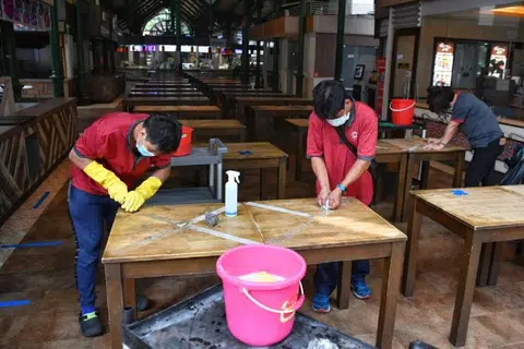 6月19日恢复堂食前的“刮刮乐”。病毒阻断期贴得很过瘾，现在刮得很吃力。（海峡时报）