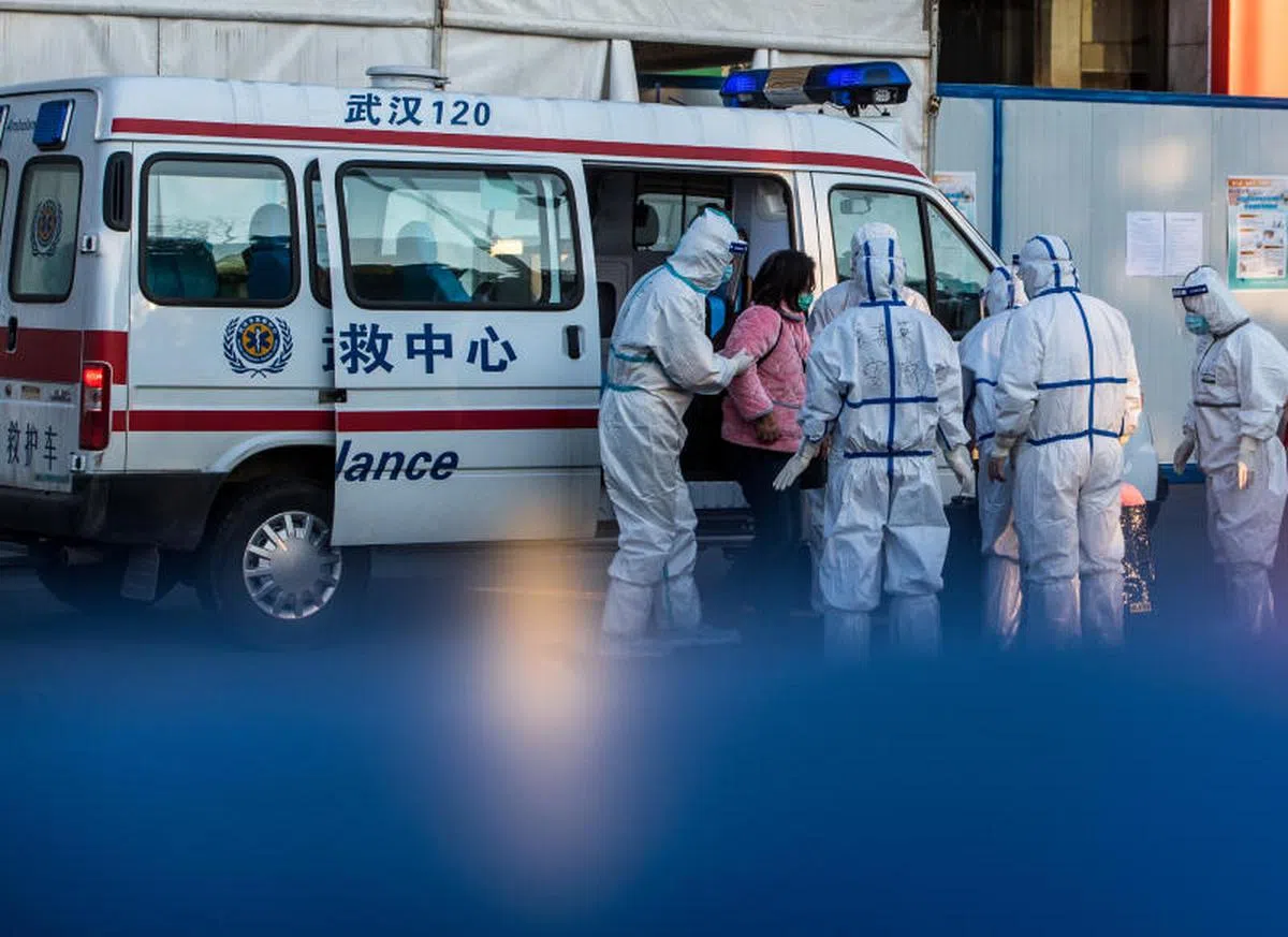  2月12日，医护人员将患者送入武汉体育中心方舱医院。（新华社） 