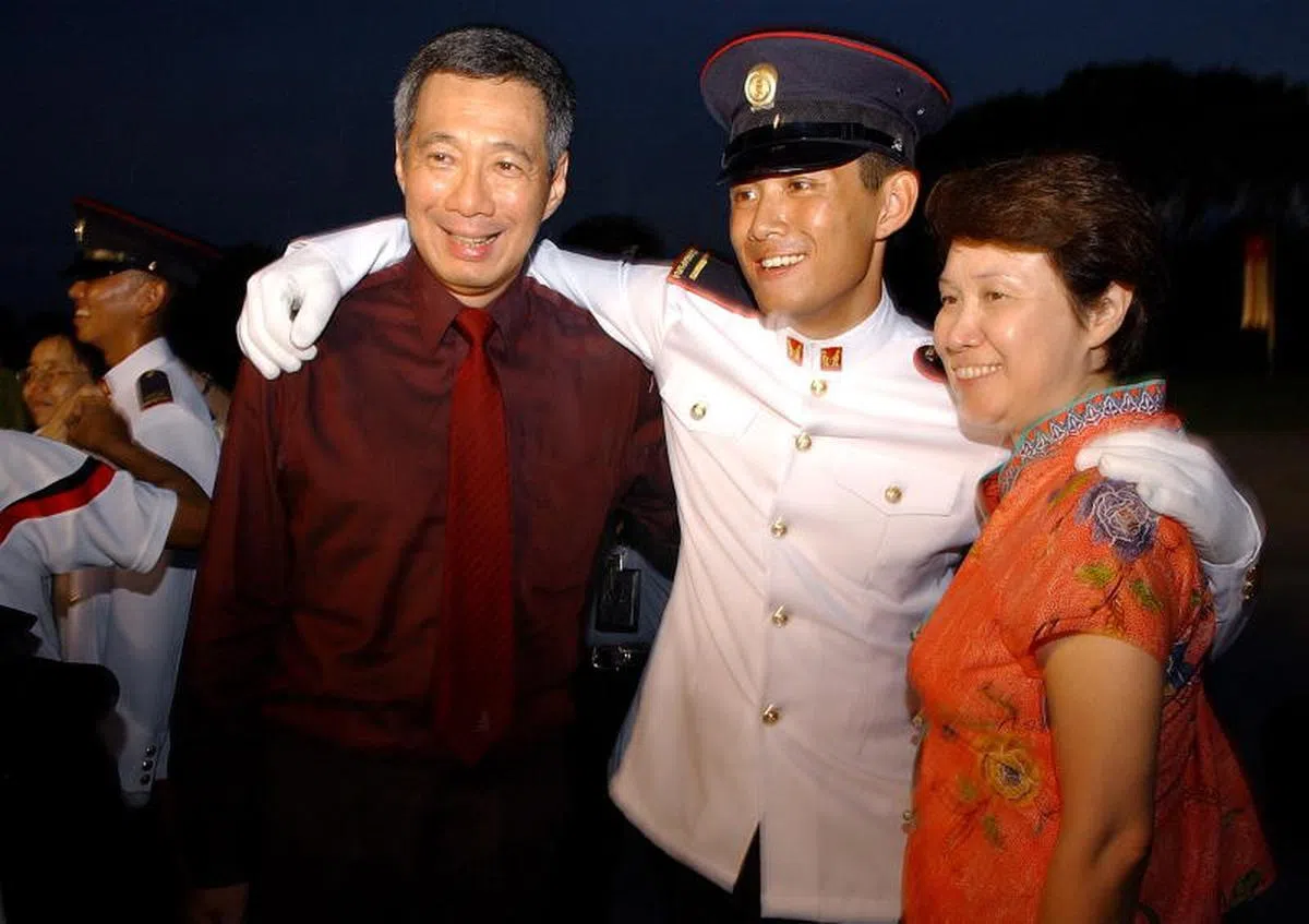  2006年，李显龙总理和夫人何晶在儿子李鸿毅的见习军官结业仪式上合影。（海峡时报） 