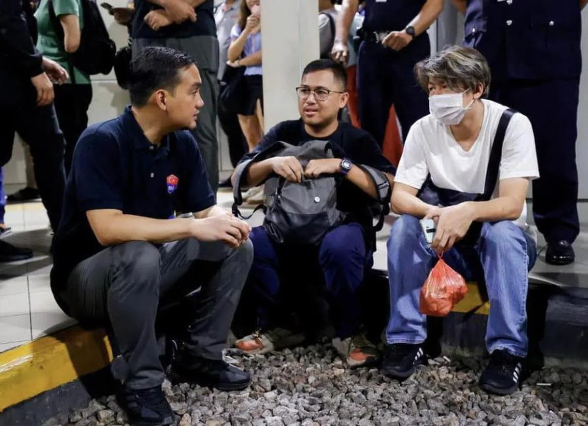 翁哈菲兹和在等候巴士的马国越堤族交流。（翁哈菲兹脸书）