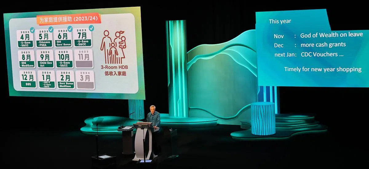 李显龙总理在2023年国庆群众大会上介绍新加坡人在2024财政预算案之前能得到的各种补助。（海峡时报）