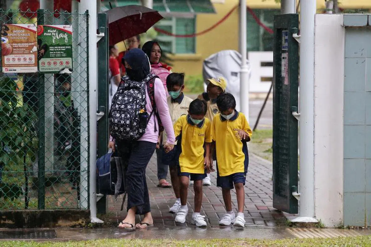 女佣借孩子放学。（海峡时报）