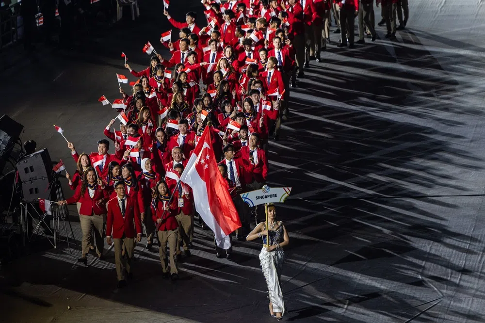 新加坡健儿进入本届东运会开幕礼会场。擎旗手是羽毛球选手杨佳敏。