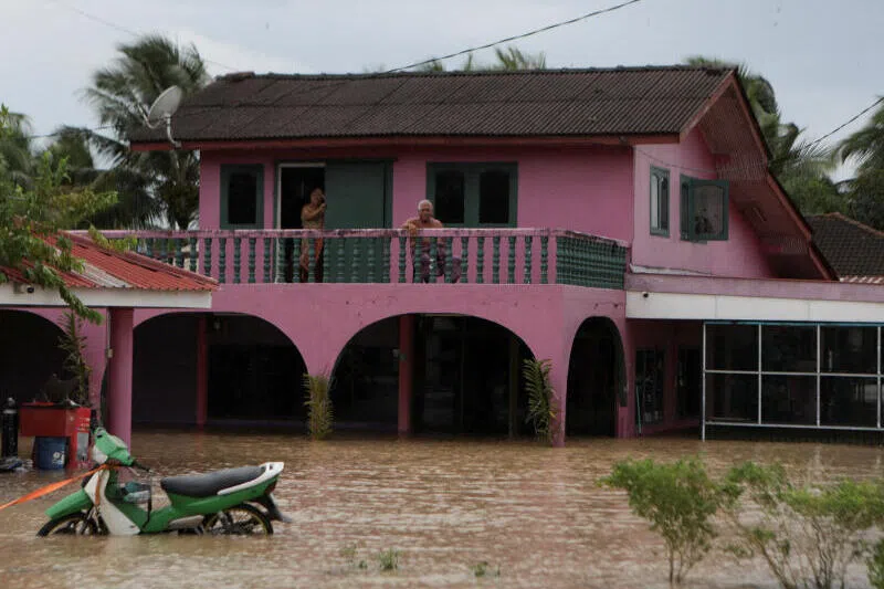 马来西亚玻璃市州加央（Kangar）在热带气旋“森雅尔”带来的暴雨侵袭下爆发洪灾，受困居民站在被淹没的家中二楼向外张望。