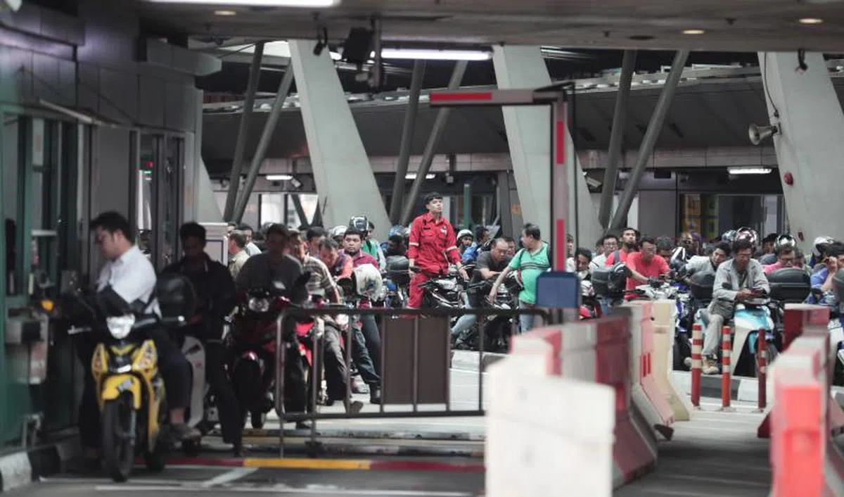 疫情前每天骑着摩托车入境我国工作的越堤族。（海峡时报）