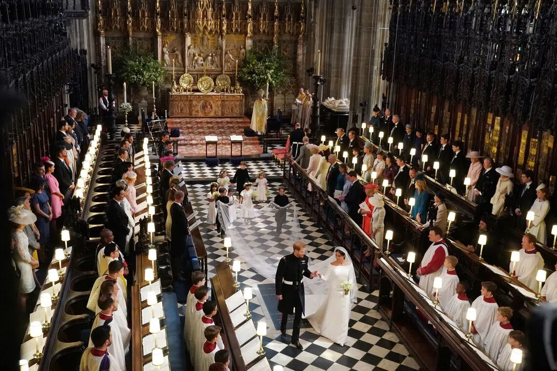 婚礼仪式结束后，哈利王子牵着妻子梅根王妃的手离开圣乔治教堂。