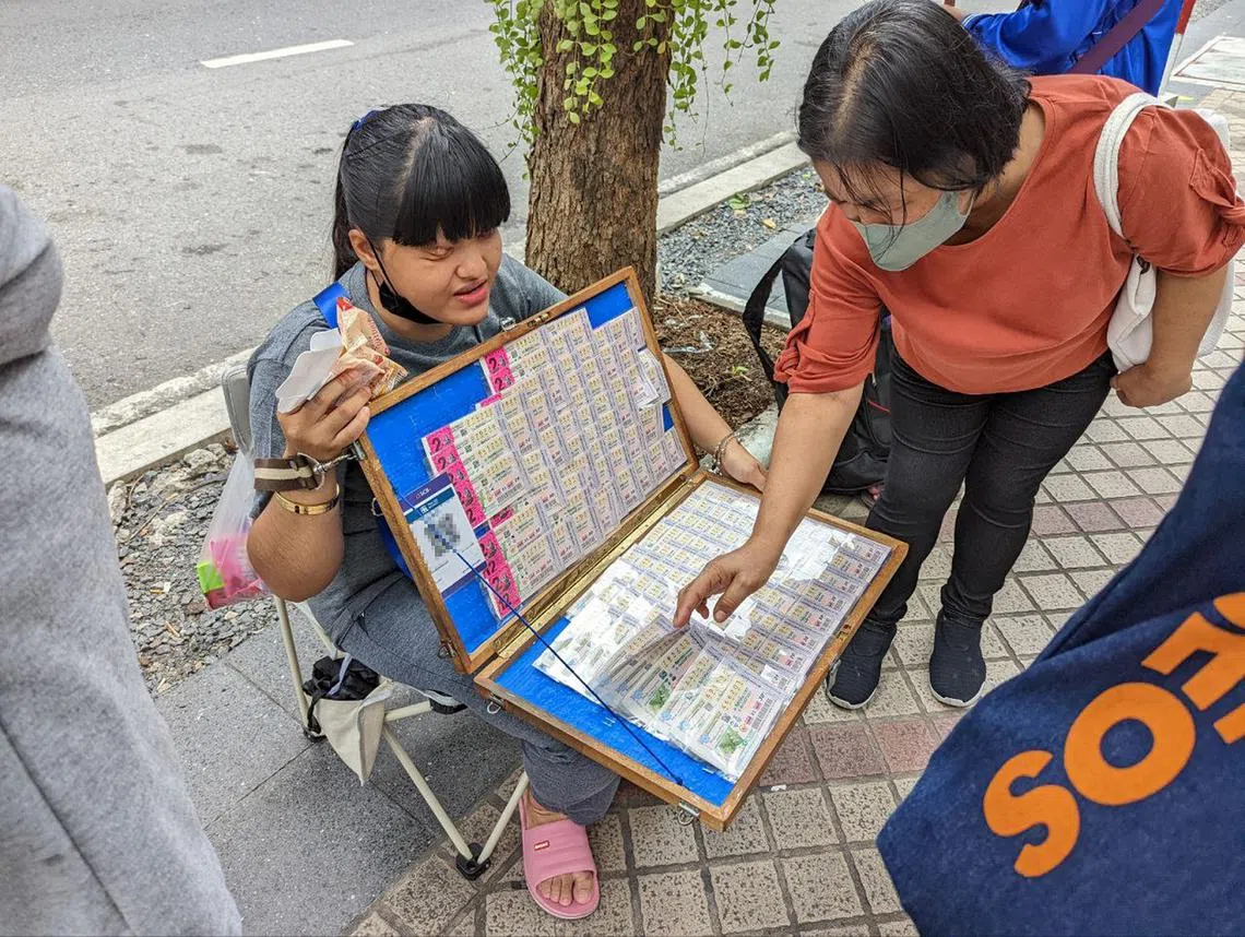 泰国街头卖彩票的小贩。（海峡时报）