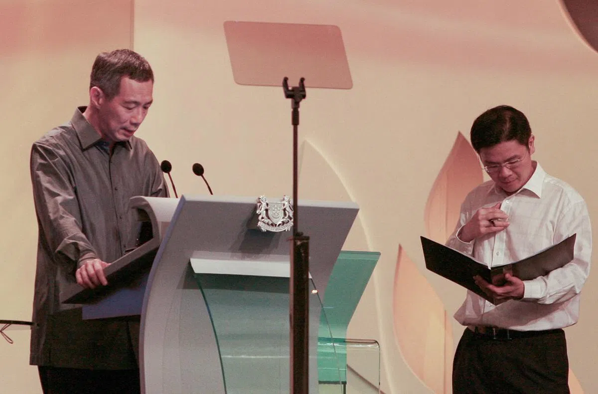 2008年，时任总理李显龙（左）为国庆群众大会演讲做准备，首席私人秘书黄循财从旁协助。（数码发展及新闻部提供）