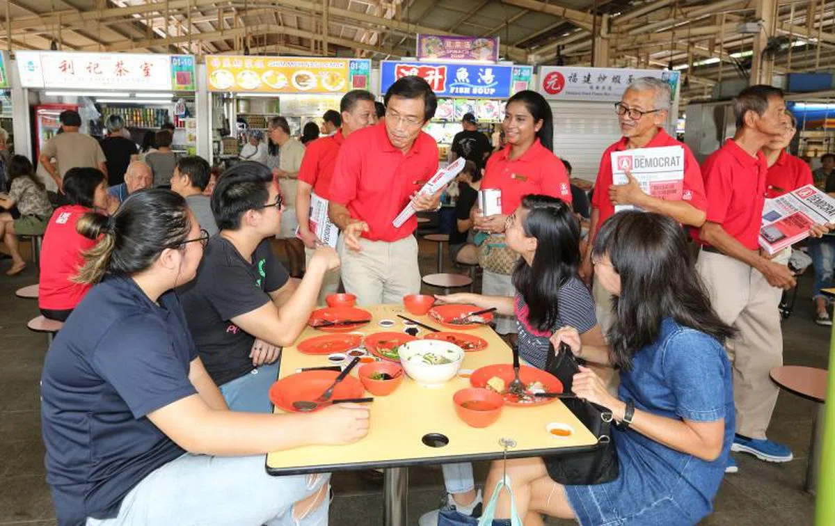  新加坡民主党秘书长徐顺全（红衣者右五）走基层。（海峡时报） 