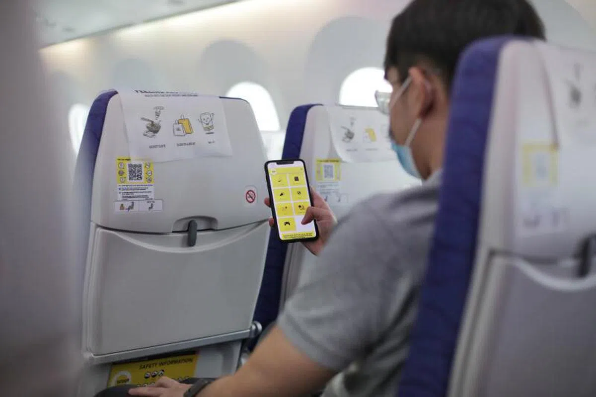 酷航乘客只要用手机扫描飞机座背的QR码，或连上“酷航空中宝”网络即可登录平台，免费使用各种功能。（海峡时报）