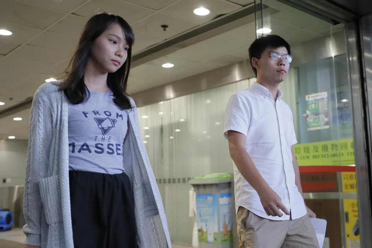  香港众志的黄之锋（右）和周庭（左）今天分别遭警方逮捕。（美联社） 