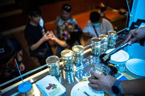 大麻在泰国合法化后，想“嗨”一下的外国旅客在泰国背包客聚集地考山路上一处大麻Cafe（流动出售点）排队购买。（路透社）