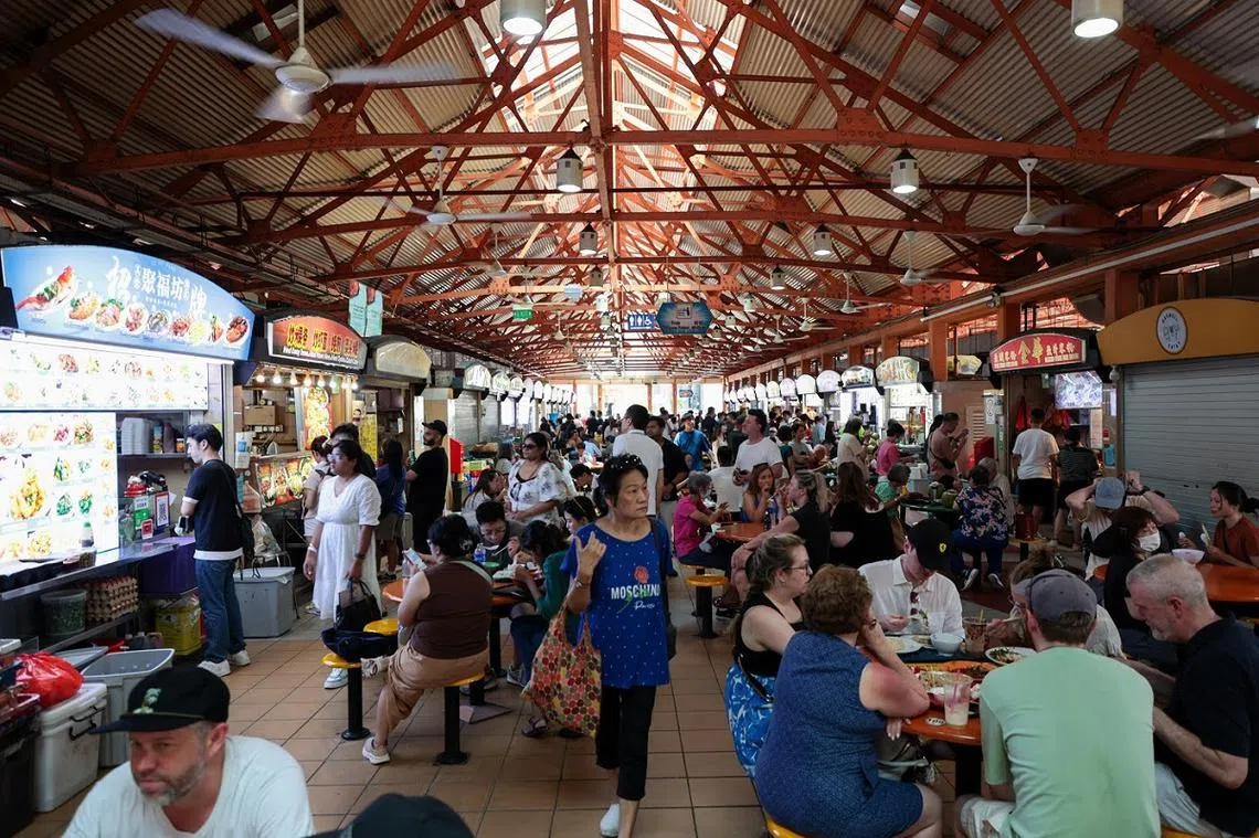 外国游客到访新加坡，少不了去小贩中心祭五脏府。（联合早报）