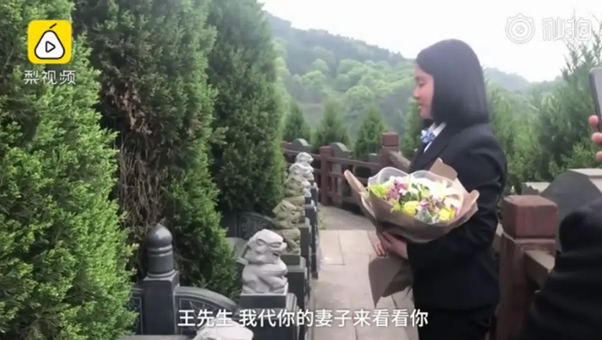  李婷婷捧着鲜花，对坟墓里的人说“王先生，我代你的妻子来看看你”。 