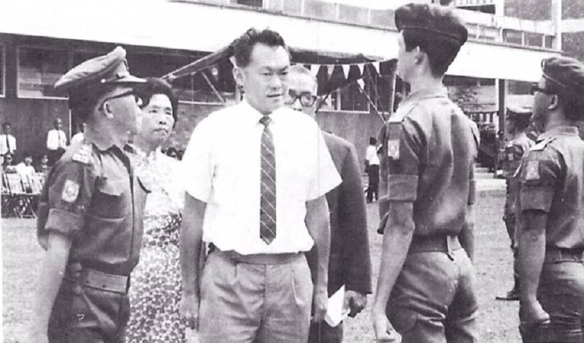  1969年8月15日，已故建国总理李光耀访问玛格烈通道的华义中学，在时任校长黄淑芬（左二）陪同下，检阅学生陆军团仪仗队。（档案照） 