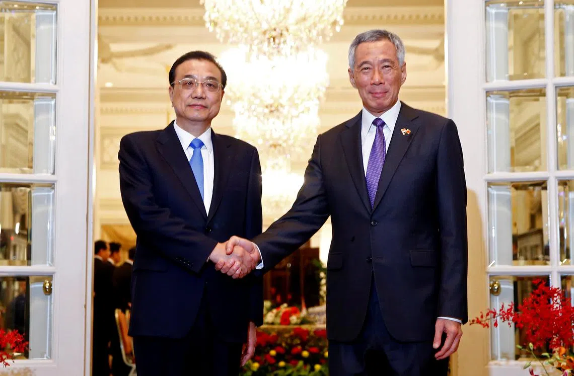 我国总理李显龙（右）在总统府会见到访的中国国务院总理李克强。（路透社）