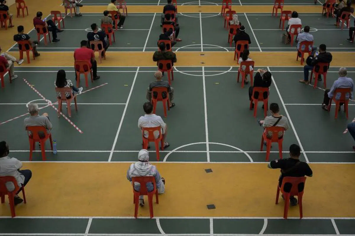  马国临时改造的病毒中心（原先是羽毛球场），民众正在排队等冠病待核酸检测。（法新社） 