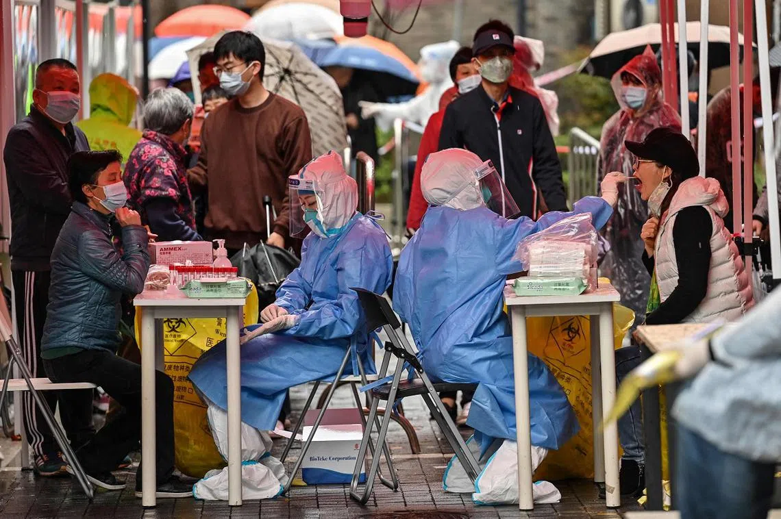 2022年3月17日，在上海市黄浦区发现冠病确诊个案后，人们在被封的街区进行冠病检测。（法新社）