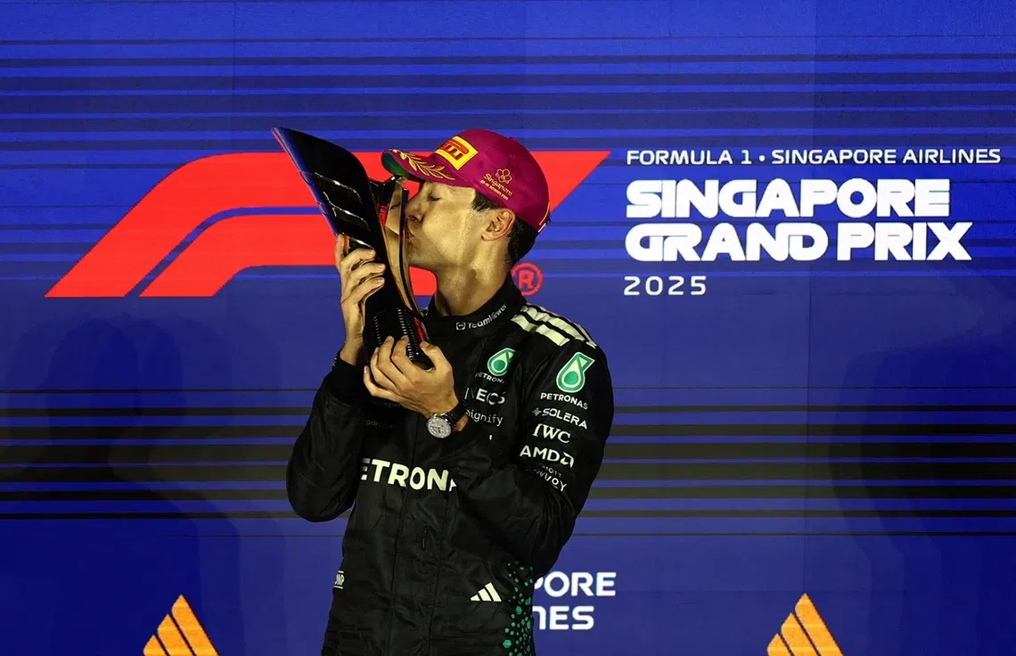 拉塞尔（Russell）10月5日晚上第一次在世界一级方程式赛车（F1）新加坡大奖赛夺冠，喜出望外的他在领奖台上亲吻奖杯。