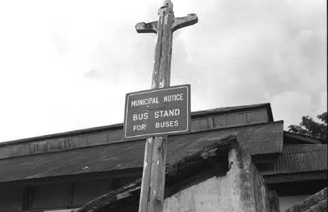 无论在是在烈日下或大雨中，1952年的新加坡巴士乘客，都得在这样的巴士站牌周围候车。（海峡时报）