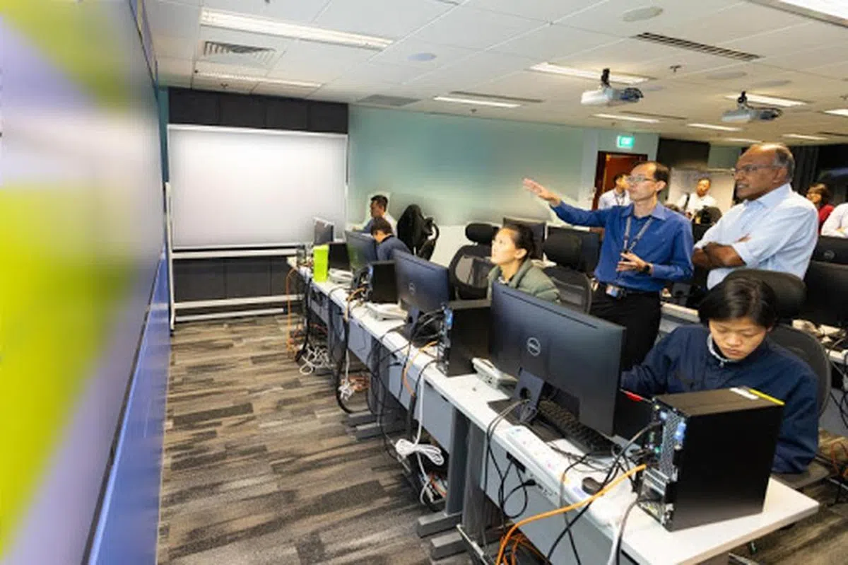  内政部长尚穆根（右一）视察设立在广东民路的新加坡警察总部内的冠病联系追踪小组。（海峡时报） 