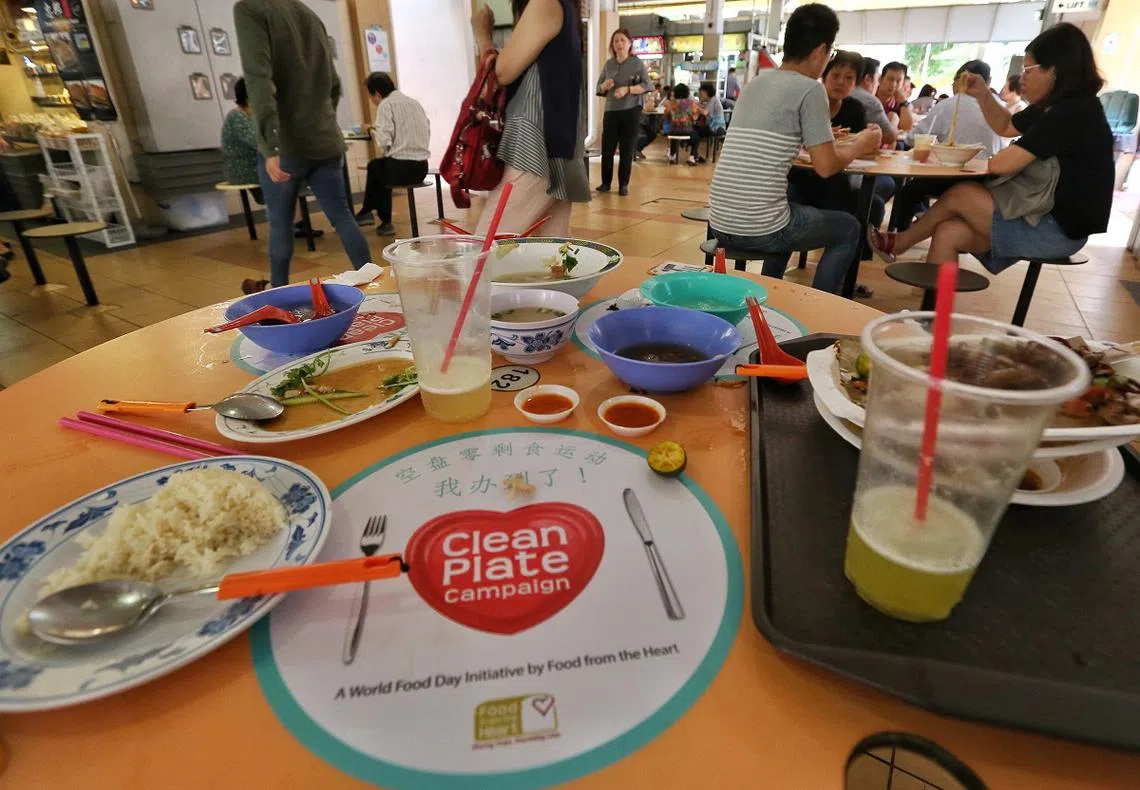 小贩中心的桌上经常可见到剩饭剩菜。（联合早报）