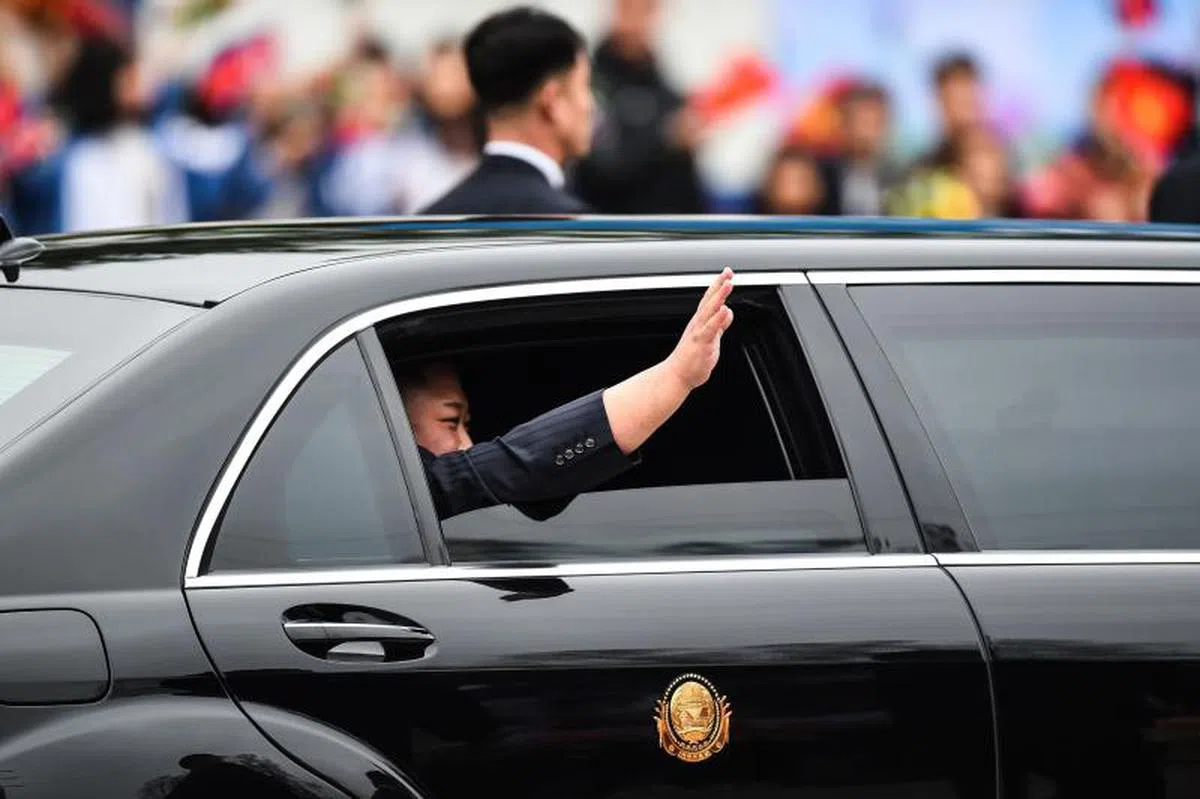  金正恩从同登坐车前往河内，途中向民众挥手致意。（法新社） 