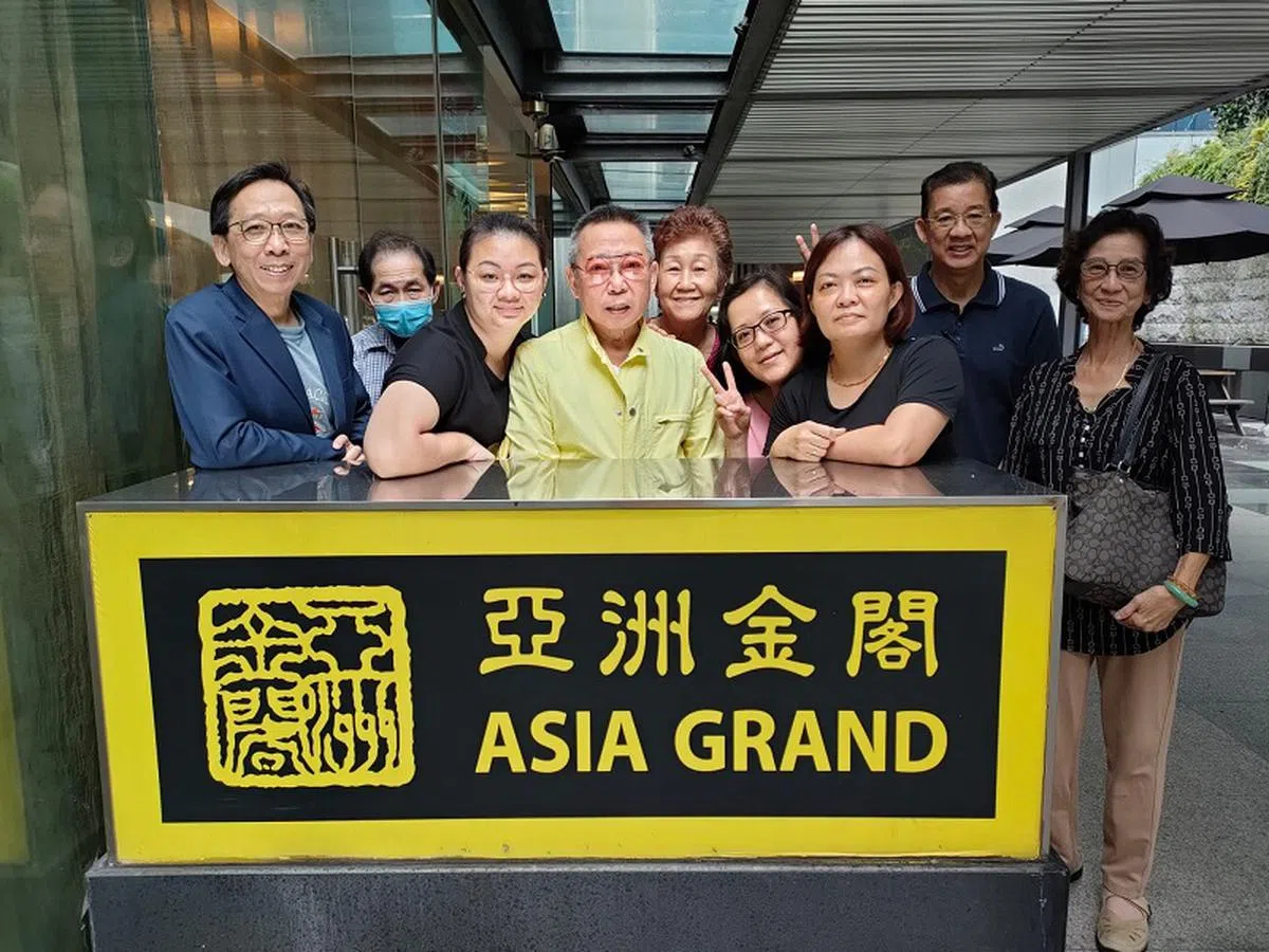 周浩鹏（左一）和大哥周景鹏（左四）及员工们在亚洲金阁旧址桥北路奥迪安大厦（Odeon Towers）留影。由于业主的重建计划，餐馆在2022年2月已经搬离经营14年的店面，直至同年9月才在费尔蒙酒店（Hotel Fairmont）恢复营业。（周浩鹏提供）
